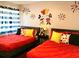 Charming bedroom featuring red bedding, cartoon wall art, and playful decor at 1122 Spaceport Ct, Kissimmee, FL 34741