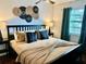 Serene bedroom with a decorative headboard, warm lighting, and elegant accents at 1122 Spaceport Ct, Kissimmee, FL 34741