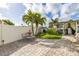 Backyard patio with a bench, fountain, and outdoor kitchen area under a covered structure surrounded by greenery at 11242 Stone Gate Ct, Orlando, FL 32837
