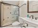 Well-equipped bathroom featuring a glass-enclosed shower and a pedestal sink with classic fixtures at 11242 Stone Gate Ct, Orlando, FL 32837