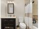 Well-lit bathroom showcasing a dark vanity, framed mirror, and shower with neutral-striped curtain at 11242 Stone Gate Ct, Orlando, FL 32837