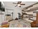 Well-decorated bedroom featuring a ceiling fan, accent wall, and a comfortable armchair at 11242 Stone Gate Ct, Orlando, FL 32837