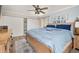 Cozy bedroom featuring a wooden bed frame, blue bedding, ceiling fan, and storage cabinets at 11242 Stone Gate Ct, Orlando, FL 32837
