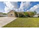 Charming single-story home with lush landscaping, arched entryway, and a brick driveway at 11242 Stone Gate Ct, Orlando, FL 32837