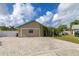 Single-story home with lush landscaping, arched entryway, and a brick driveway and white fence at 11242 Stone Gate Ct, Orlando, FL 32837