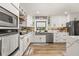 Modern kitchen with white cabinets, stainless steel appliances, and wood look flooring at 11242 Stone Gate Ct, Orlando, FL 32837