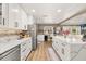 Bright kitchen boasts quartz counters, white cabinets, stainless appliances, and breakfast bar seating at 11242 Stone Gate Ct, Orlando, FL 32837