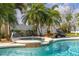 Relaxing pool area with water feature, tropical palms, and lounge seating at 11242 Stone Gate Ct, Orlando, FL 32837