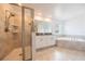 This bathroom includes a glass shower, double vanity, soaking tub, and neutral tile flooring at 11456 Rhyme Ave, Orlando, FL 32832