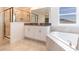 This bathroom offers a glass shower, double vanity, and soaking tub by the window at 11456 Rhyme Ave, Orlando, FL 32832