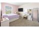 Cozy bedroom with large window, comfortable bed, desk, vanity, and plush carpeting at 11456 Rhyme Ave, Orlando, FL 32832