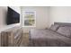 Comfortable bedroom featuring a large window, neutral colors, and a wall-mounted TV at 11456 Rhyme Ave, Orlando, FL 32832