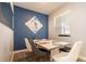 Stylish dining area features a modern table, trendy seating, and an eye-catching blue accent wall at 11456 Rhyme Ave, Orlando, FL 32832