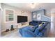 Open-concept living room with a stylish sectional couch, a large TV and modern decor at 11456 Rhyme Ave, Orlando, FL 32832