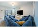 Bright living room with a comfortable sectional couch, large TV, and sliding glass doors at 11456 Rhyme Ave, Orlando, FL 32832