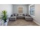Bright living room features a spacious sectional sofa, large windows, and modern tile flooring at 11456 Rhyme Ave, Orlando, FL 32832