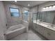 Modern bathroom with marble-tiled walls, a soaking tub, and a glass-enclosed shower at 1400 Fair Oaks Ave, Kissimmee, FL 34744