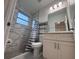 Modern bathroom featuring a gray marble-tiled shower, toilet, and vanity with a quartz countertop at 1400 Fair Oaks Ave, Kissimmee, FL 34744