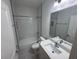Cozy bathroom featuring a shower-tub combo with marble-style tiles and a white quartz countertop at 1400 Fair Oaks Ave, Kissimmee, FL 34744