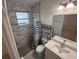 Modern bathroom with gray marble-tiled shower, toilet, and vanity with a quartz countertop at 1400 Fair Oaks Ave, Kissimmee, FL 34744