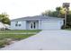 Charming single-story home with light blue exterior, white trim, and a well-manicured lawn at 1400 Fair Oaks Ave, Kissimmee, FL 34744
