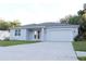 Charming single-story home with light blue exterior, white trim, and a well-manicured lawn at 1400 Fair Oaks Ave, Kissimmee, FL 34744