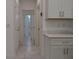Bright hallway featuring white cabinets, doors, and tile flooring, leading to other rooms in the home at 1400 Fair Oaks Ave, Kissimmee, FL 34744