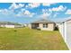Spacious backyard with a well-kept lawn, a white fence, and a view of neighboring homes at 1507 Bitteroot St, Kissimmee, FL 34744