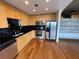 Modern open kitchen featuring light wood cabinets, stainless steel appliances, and a black backsplash at 155 S Court Ave # 1308, Orlando, FL 32801