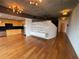Wide angle of an open living area with hardwood flooring, a partial view of the kitchen and a custom shelving unit at 155 S Court Ave # 1308, Orlando, FL 32801