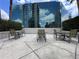 Outdoor seating area featuring chairs, tables, and views of the adjacent glass building at 155 S Court Ave # 1308, Orlando, FL 32801