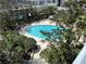 Sparkling pool with lounge chairs surrounded by lush trees, providing a serene escape at 155 S Court Ave # 1308, Orlando, FL 32801