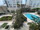 Aerial view of a sparkling pool surrounded by trees and greenery in a condominium complex at 155 S Court Ave # 1308, Orlando, FL 32801