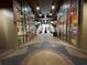 Shopping center with store fronts, escalators, and a statue at 155 S Court Ave # 1308, Orlando, FL 32801