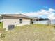 Lush backyard with a well-maintained lawn, bordered by a privacy fence, and modern AC unit at 16588 Centipede St, Clermont, FL 34714
