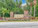 Stone entrance sign to Sawgrass Bay community with lush landscaping and mature palm trees, welcoming residents at 16588 Centipede St, Clermont, FL 34714