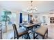 Well-lit dining area with a wood table, stylish chandelier, and sliding glass doors to the backyard at 16588 Centipede St, Clermont, FL 34714