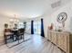 Open dining space with a modern chandelier, wood table, and sliding glass doors to the outdoor area at 16588 Centipede St, Clermont, FL 34714