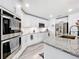 Close-up of a modern kitchen with granite countertops, white cabinets, and stainless steel appliances at 16588 Centipede St, Clermont, FL 34714