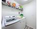 Convenient laundry room equipped with a modern washer and dryer and storage shelving at 16588 Centipede St, Clermont, FL 34714