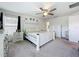 Spacious main bedroom featuring a large bed, ceiling fan, neutral carpet, and a window at 16588 Centipede St, Clermont, FL 34714
