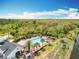 Aerial view of a community pool with lounge chairs and tables next to lush green trees at 16588 Centipede St, Clermont, FL 34714