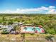 Aerial view of a community pool surrounded by lush landscaping and a relaxing outdoor area with tables and lounge chairs at 16588 Centipede St, Clermont, FL 34714