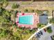 Aerial view of community pool featuring lounge chairs, umbrellas, pool house and parking at 16588 Centipede St, Clermont, FL 34714