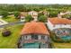 Aerial view of residential neighborhood highlighting tile roofs, pool enclosures and green spaces at 16621 Caribbean Breeze Way, Clermont, FL 34714