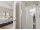 Modern bathroom featuring a glass enclosed shower and a bedroom through an open door at 16621 Caribbean Breeze Way, Clermont, FL 34714