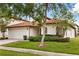 Attractive one-story home with a red tile roof, manicured lawn, and two-car garage at 16621 Caribbean Breeze Way, Clermont, FL 34714