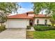 Charming single-story home featuring a red tile roof and attached two-car garage at 16621 Caribbean Breeze Way, Clermont, FL 34714