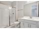 Bathroom with shower featuring glass doors, white vanity, and decorative mirror at 1737 Carnelian St, Deland, FL 32720