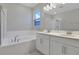 Bright bathroom with double sink vanity, soaking tub, and shower with glass door at 1737 Carnelian St, Deland, FL 32720